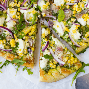 This pizza with arugula pesto tastes like summer. It’s sweet, salty, tangy, chewy, crunchy, subtly spicy, and topped with creamy Ricotta cheese.
